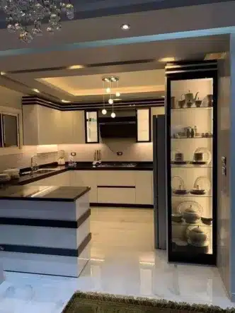 Modular kitchen in white and black combination with crockery unit — modern, space-saving design for small Delhi homes — organized and stylish storage solution